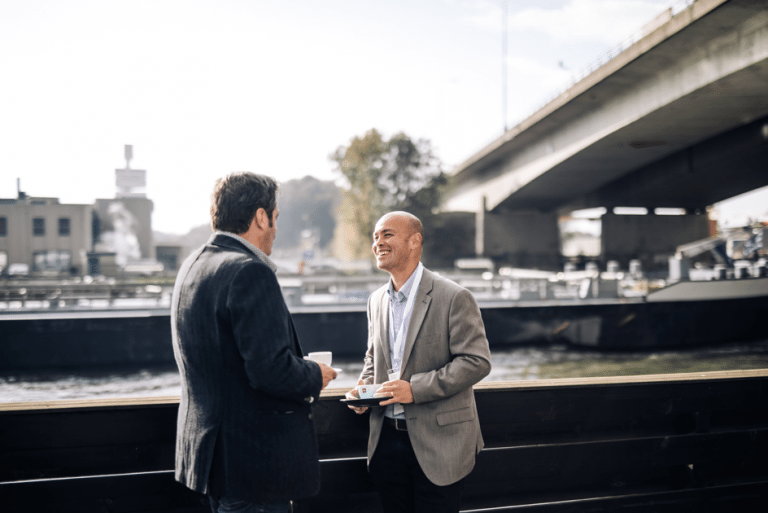 Zwei Menschen trinken Kaffee vor einem Fluss